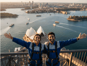 An image of a couple or small group at the summit of the Bridge, arms outstretched, looking out over the panoramic Sydney Harbour.